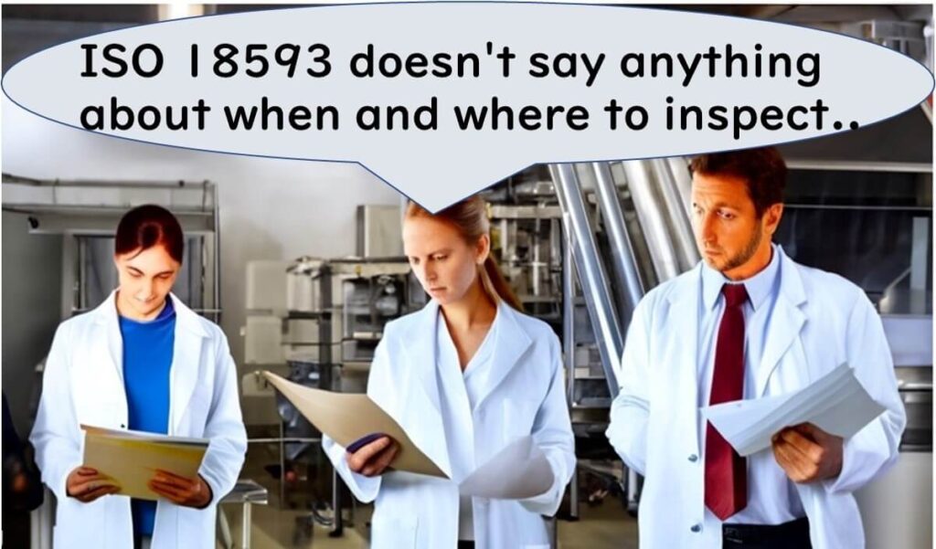 Three food factory staff in lab coats reviewing documents in a processing facility, with a speech bubble saying: “ISO 18593 doesn't say anything about when and where to inspect..”