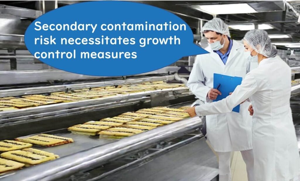 Two food safety inspectors in protective clothing examining ready-to-eat pastries on a production line, with a speech bubble stating 'Secondary contamination risk necessitates growth control measures'.